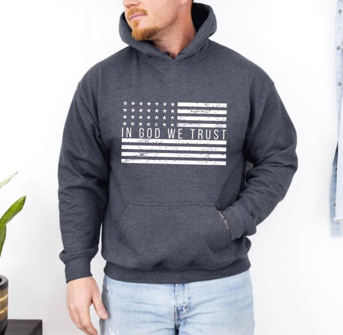 Dark gray hoodie with a distressed American flag that says, "In God we trust" across the middle of the flag.