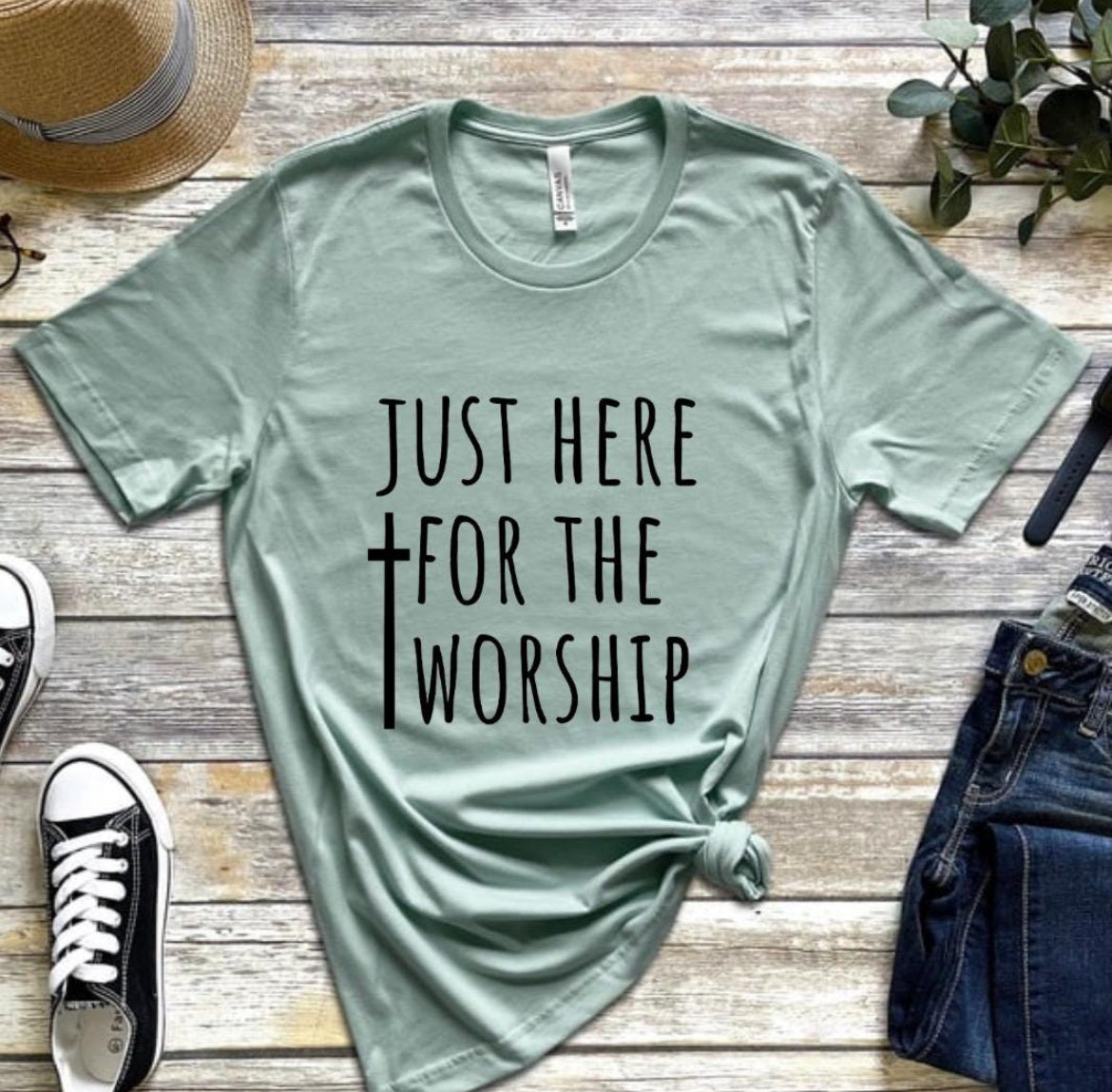 Dusty green crewneck t-shirt that says, “just here for the worship” with a cross on it.