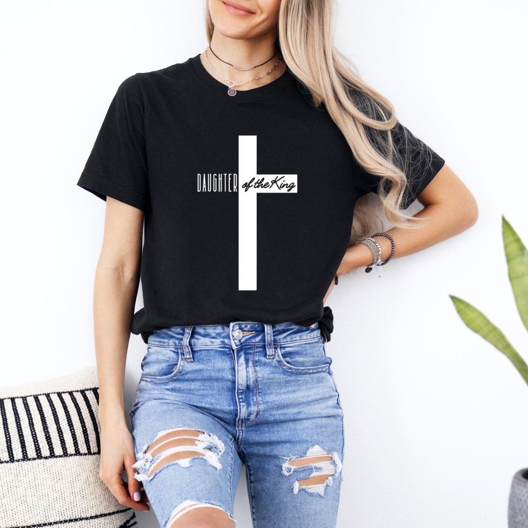 Black crewneck t-shirt that says, “Daughter of the King” running through a cross.