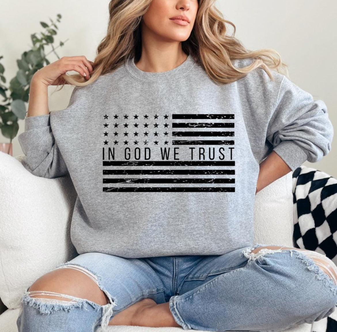 Light gray crewneck sweatshirt with a distressed American flag that says, "In God we trust" across the middle of the flag.
