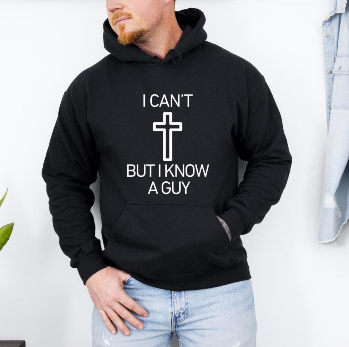 Black hoodie that says, "I can't but I know a guy" with a cross in the middle.