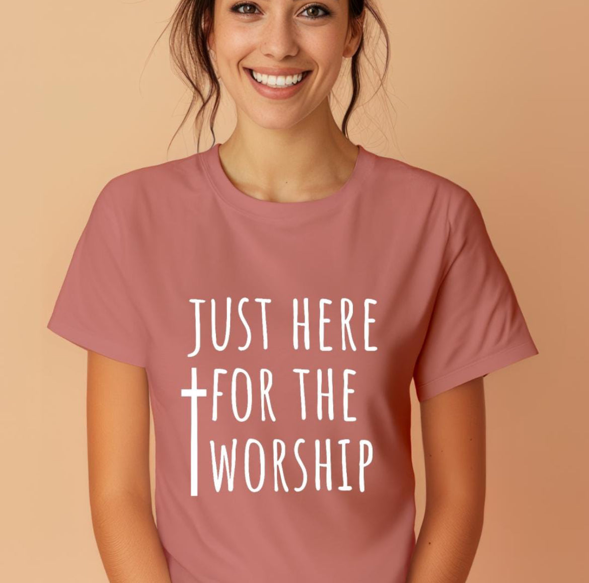 Mauve crewneck t-shirt that says, “just here for the worship” with a cross on it.