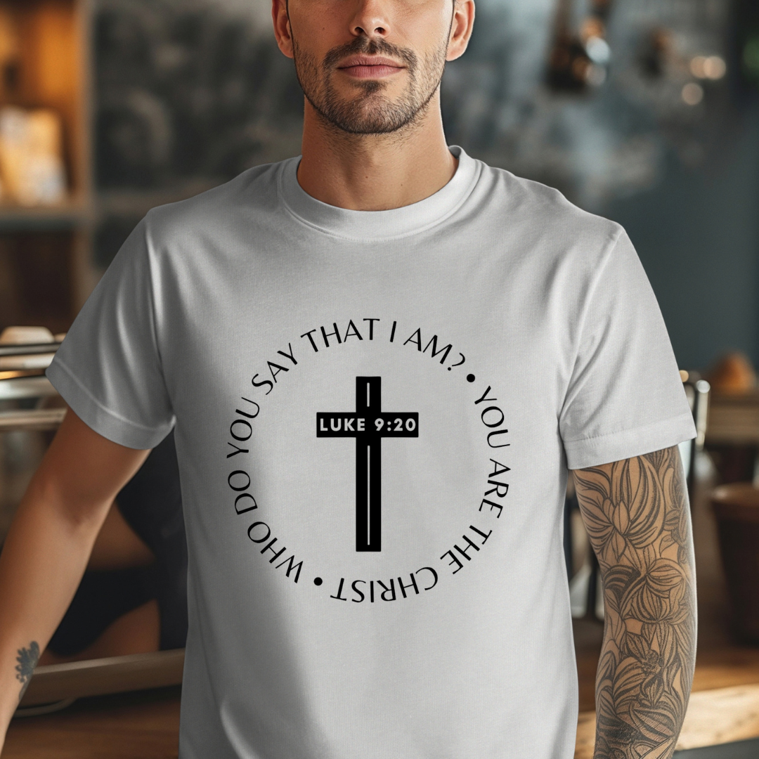 Gray crewneck t-shirt that says, “who do you say that I am? you are the Christ?” With a cross that says, “Luke 9:29” through the middle.