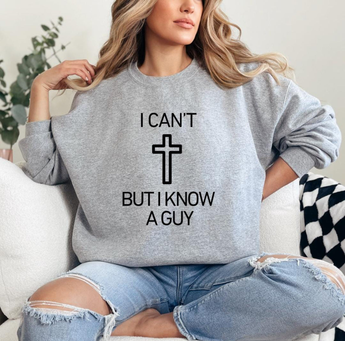 Light grey crewneck sweatshirt that says, "I can't but I know a guy" with a cross in the middle.