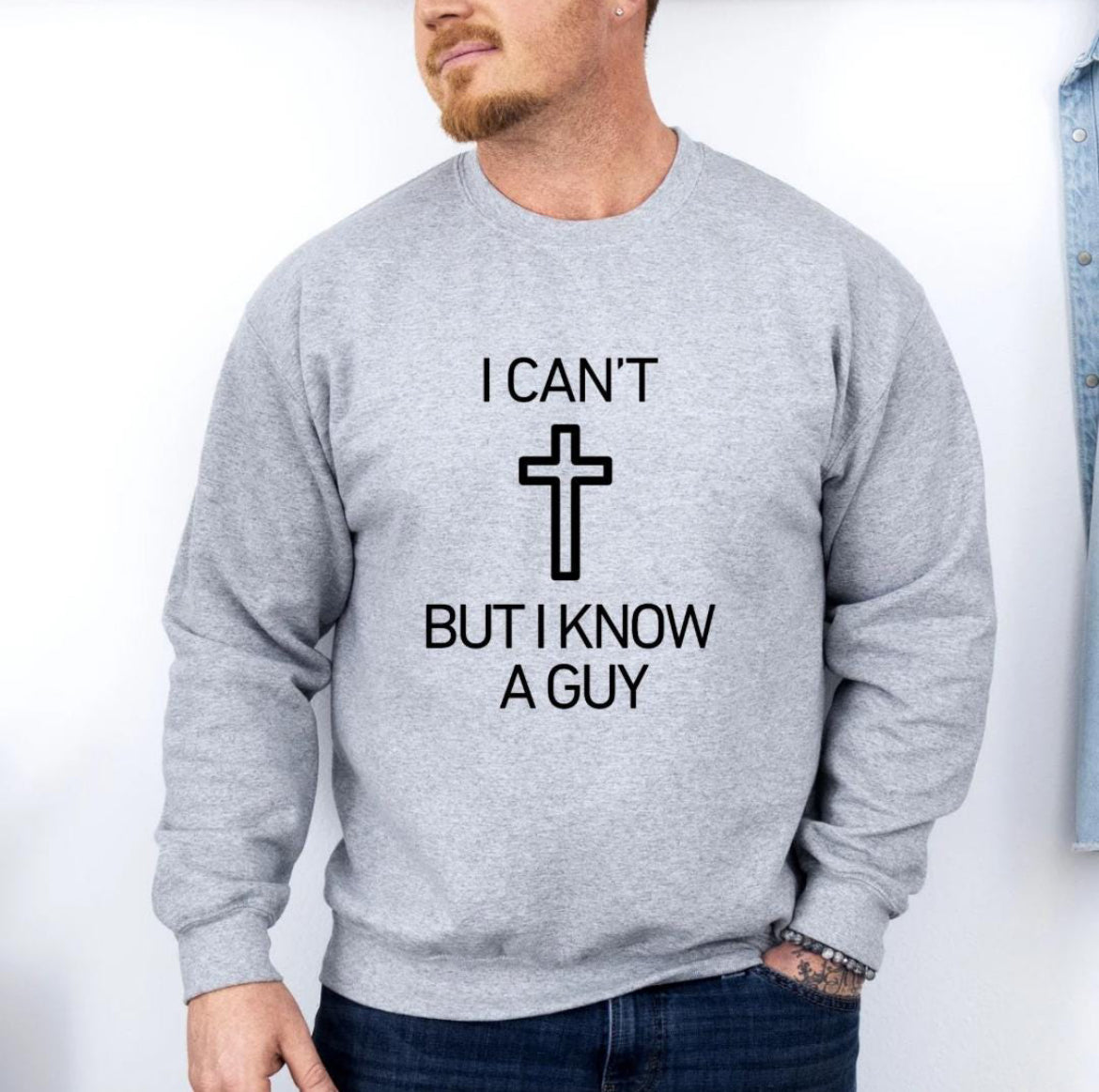 Light gray crewneck sweatshirt that says, "I can't but I know a guy" with a cross in the middle.