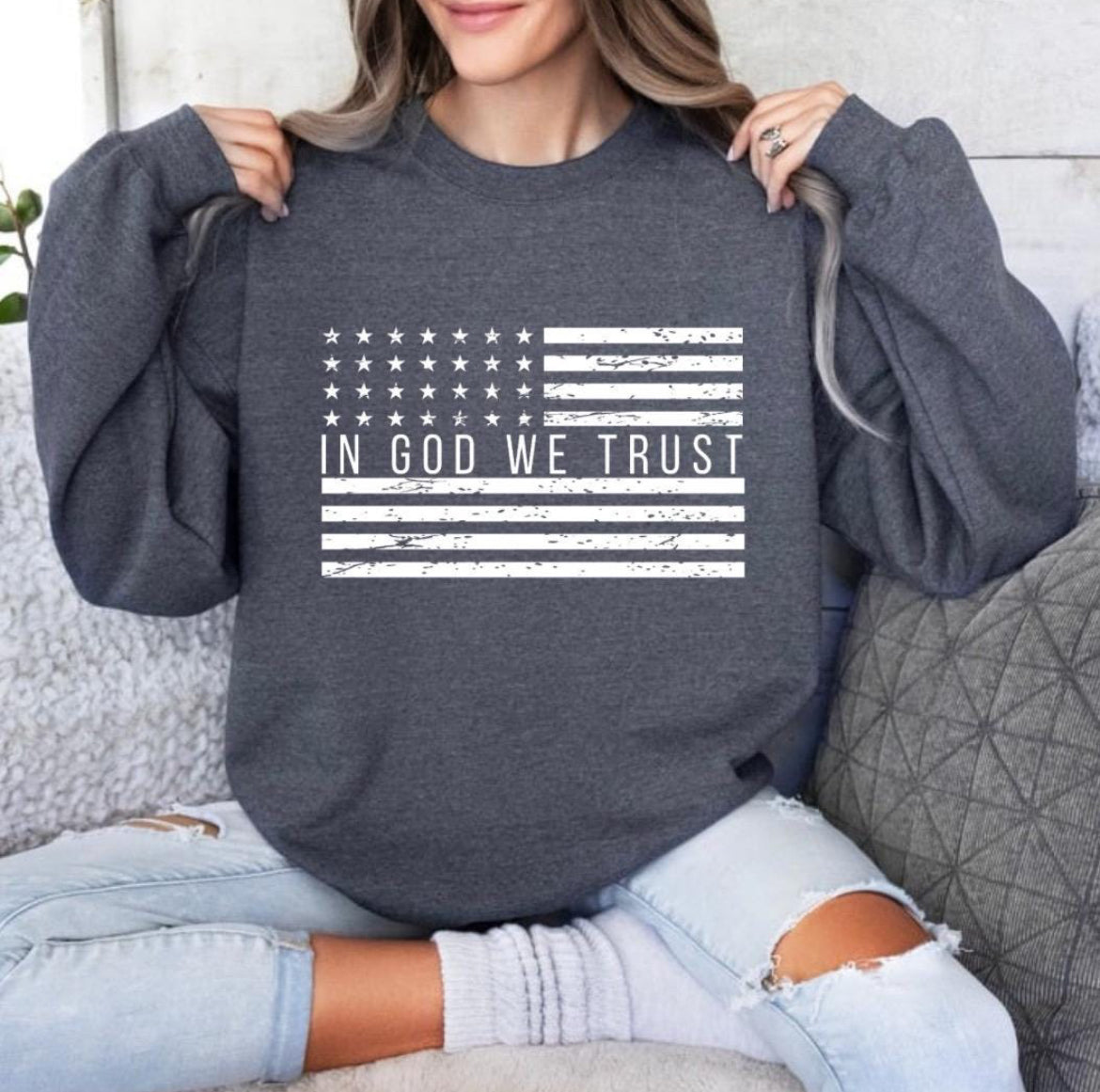 Dark grey crewneck sweatshirt with a distressed American flag that says, "In God we trust" across the middle of the flag.