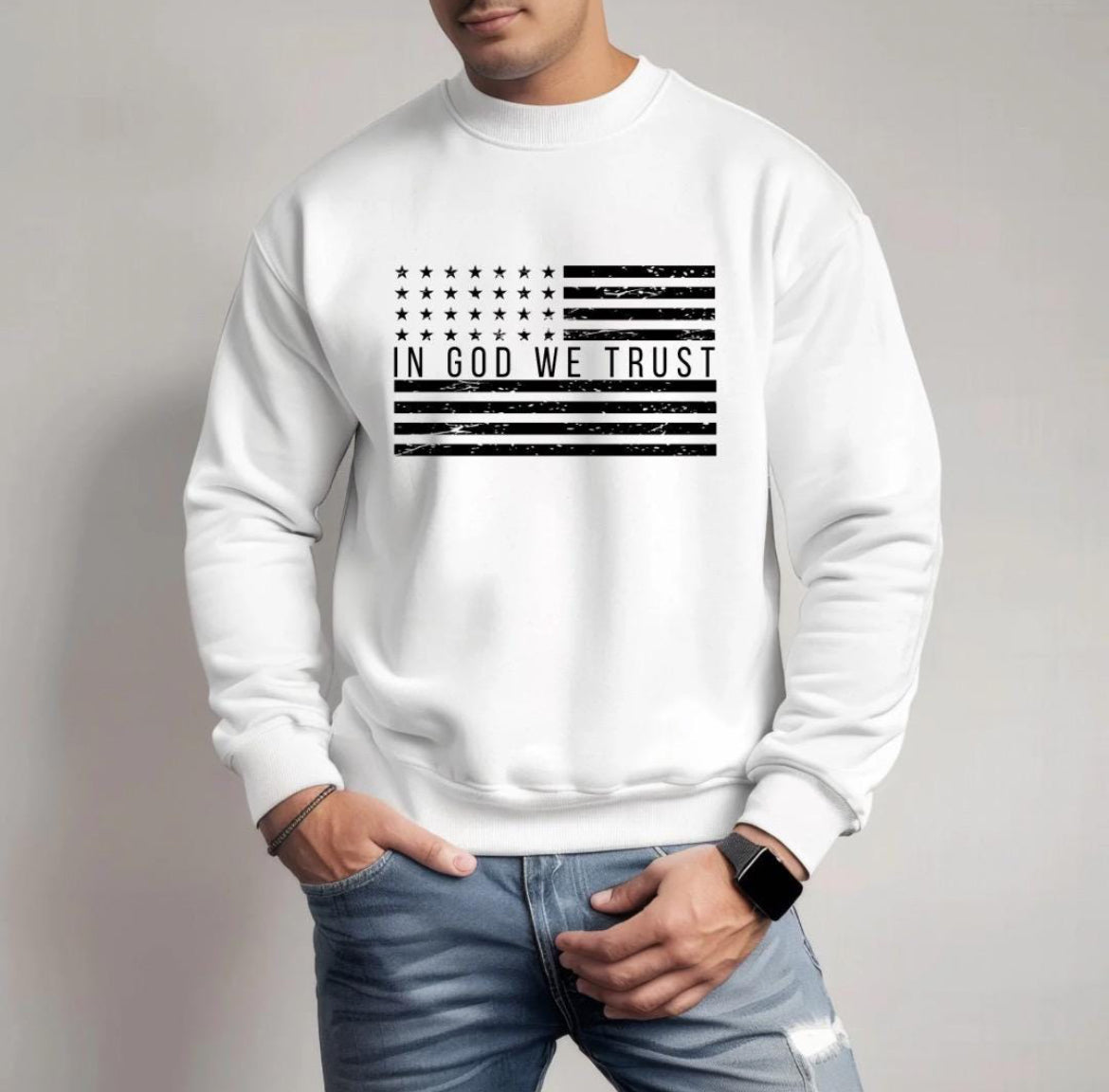 White crewneck sweatshirt with a distressed American flag that says, "In God we trust" across the middle of the flag.