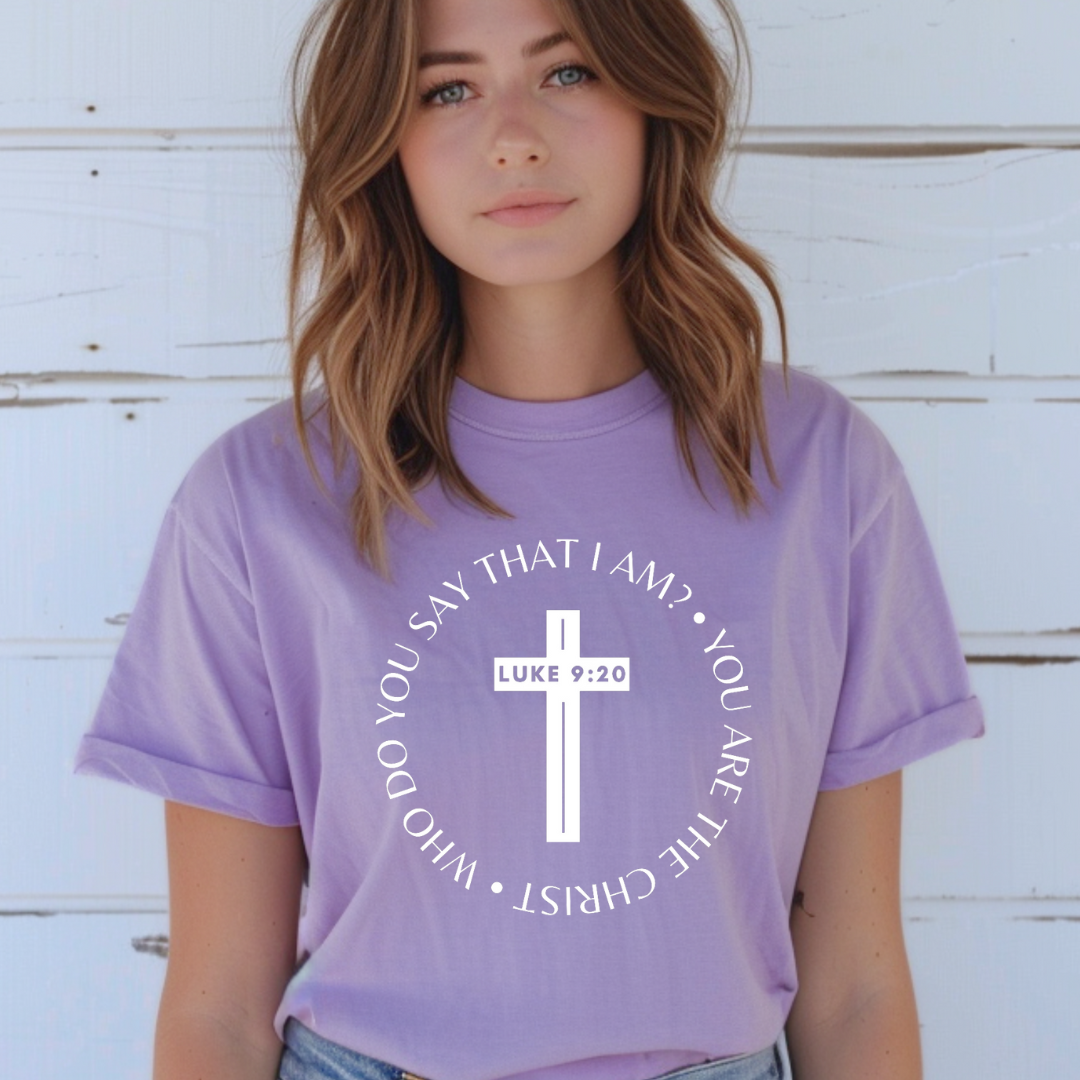 Lavender crewneck t-shirt that says, “who do you say that I am? you are the Christ?” With a cross that says, “Luke 9:29” through the middle.