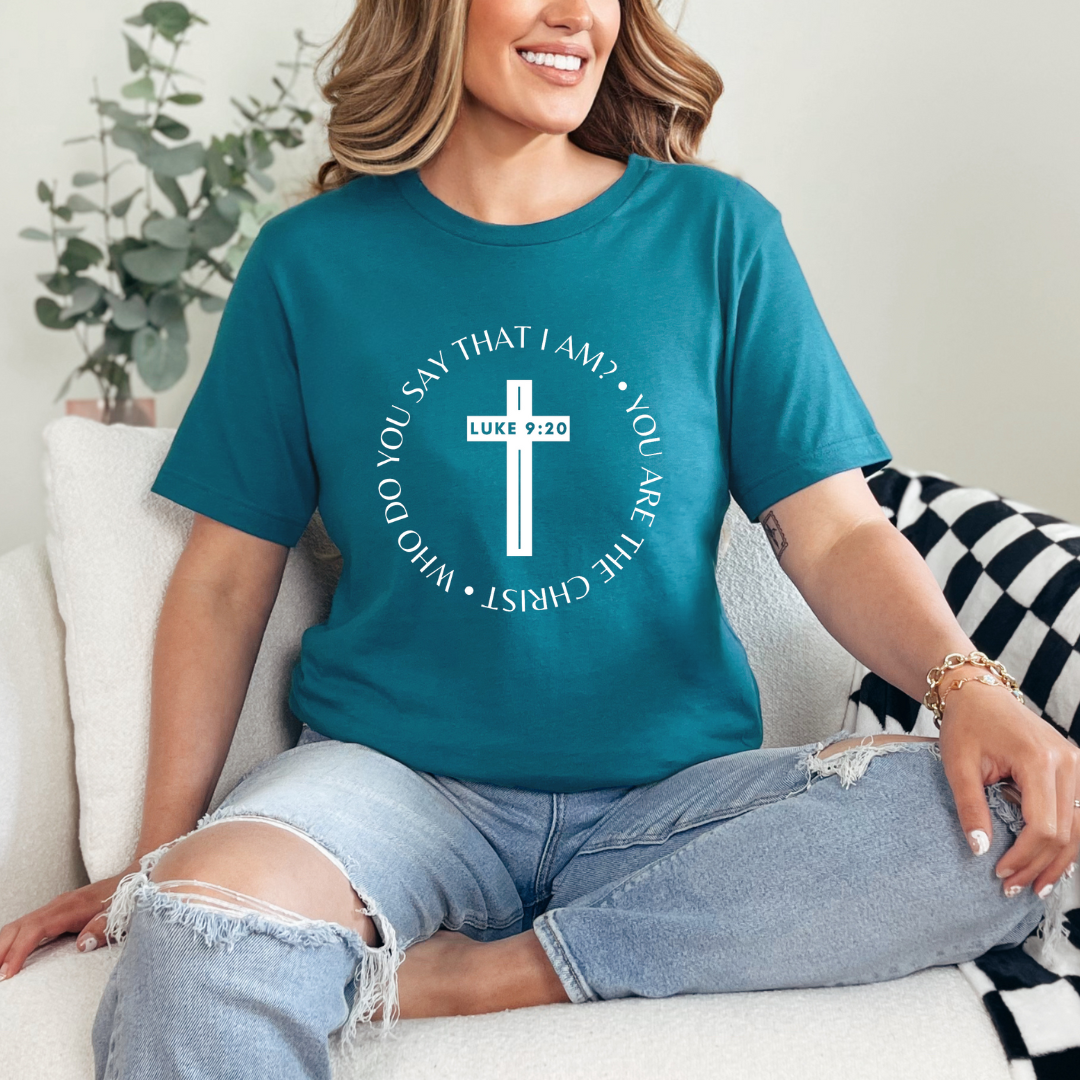 Deep teal crewneck t-shirt that says, “who do you say that I am? you are the Christ?” With a cross that says, “Luke 9:29” through the middle.