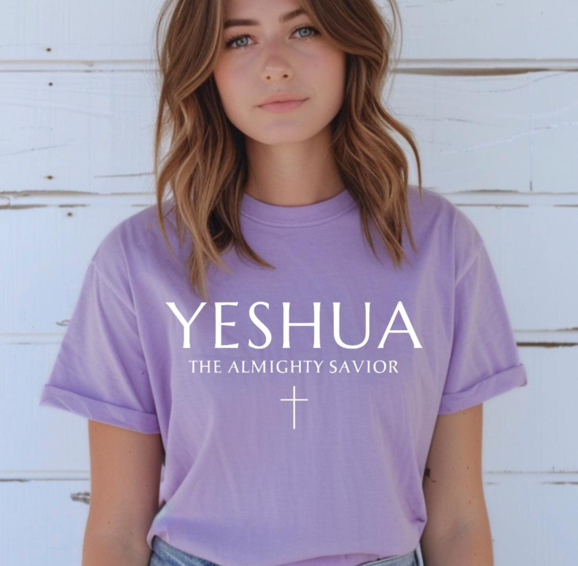 Lavender Crewneck T-shirt that says, “Yeshua” in large letters. Underneath in smaller letters it says, “the almighty savior” and under that is a small cross.