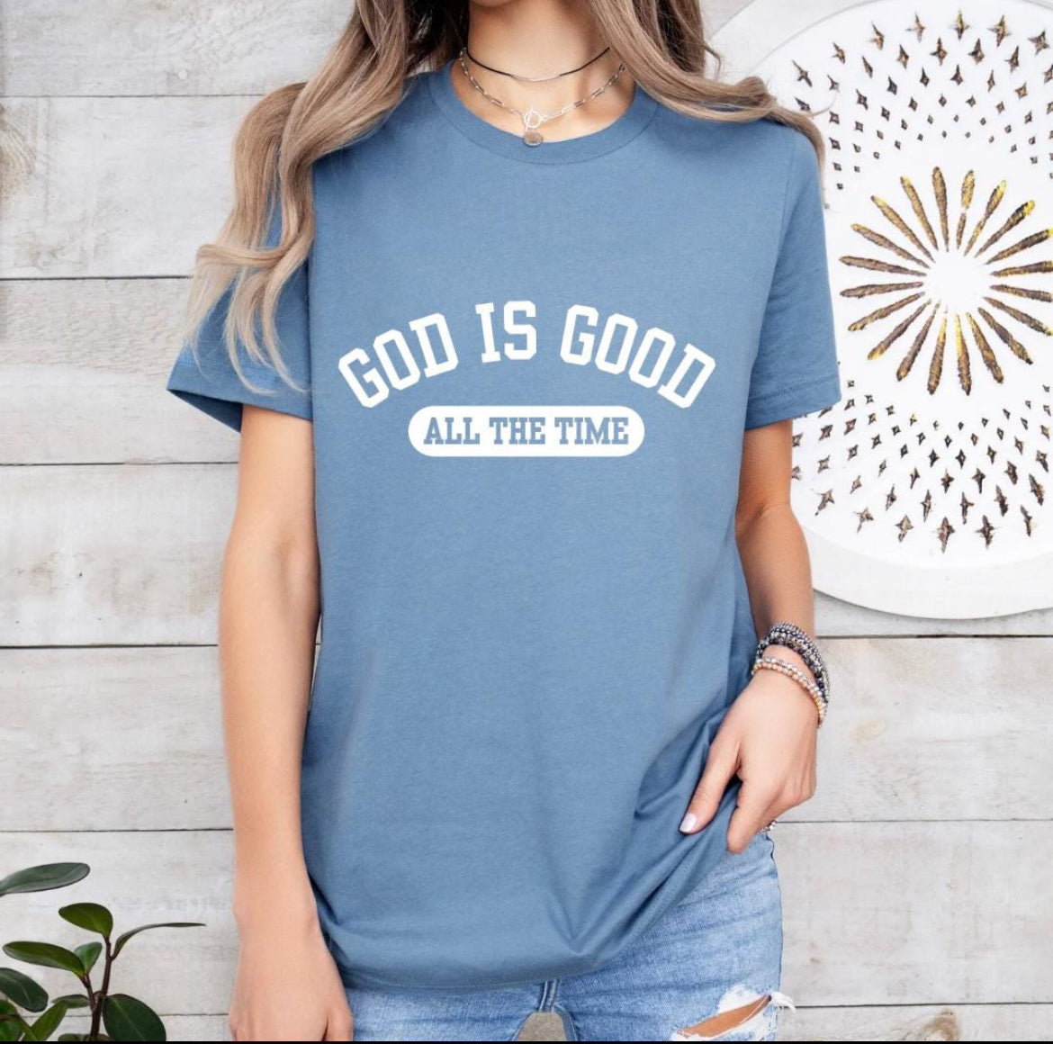 Steel blue crewneck t-shirt that says, “God is good all the time”.