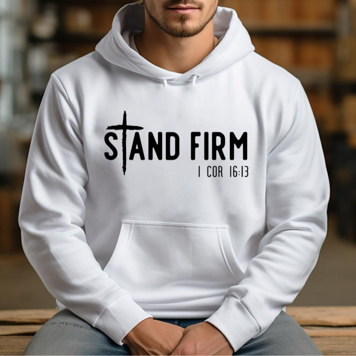 White hoodie that says, "Stand firm" where the "t" is a cross. Underneath in smaller letters it says, "1 Corinthians 16 verse 13."