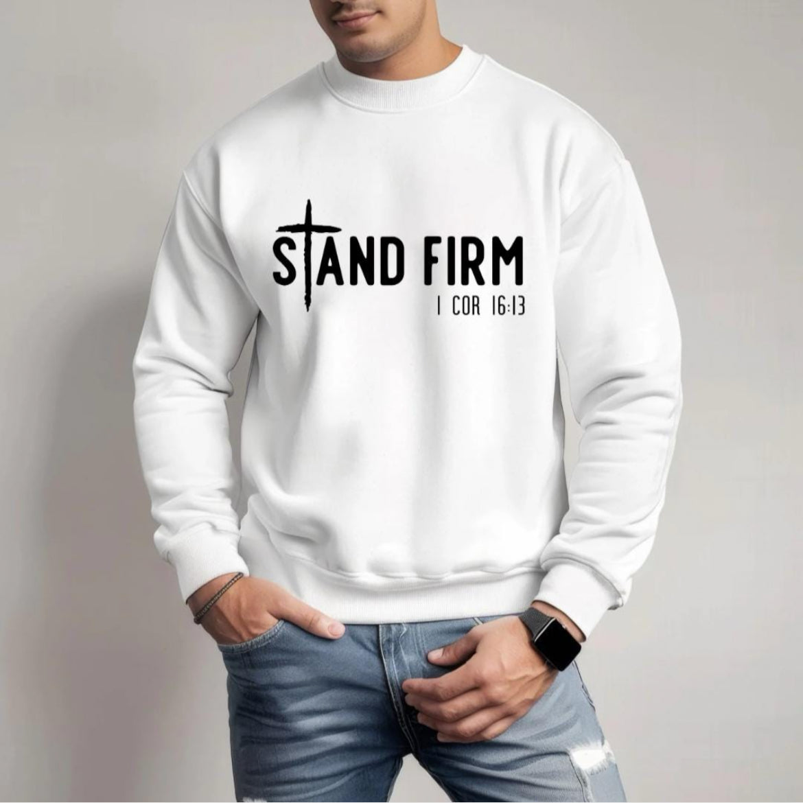 White crewneck sweatshirt that says, "Stand firm" where the "t" is a cross. Underneath in smaller letters it says, "1 Corinthians 16 verse 13."