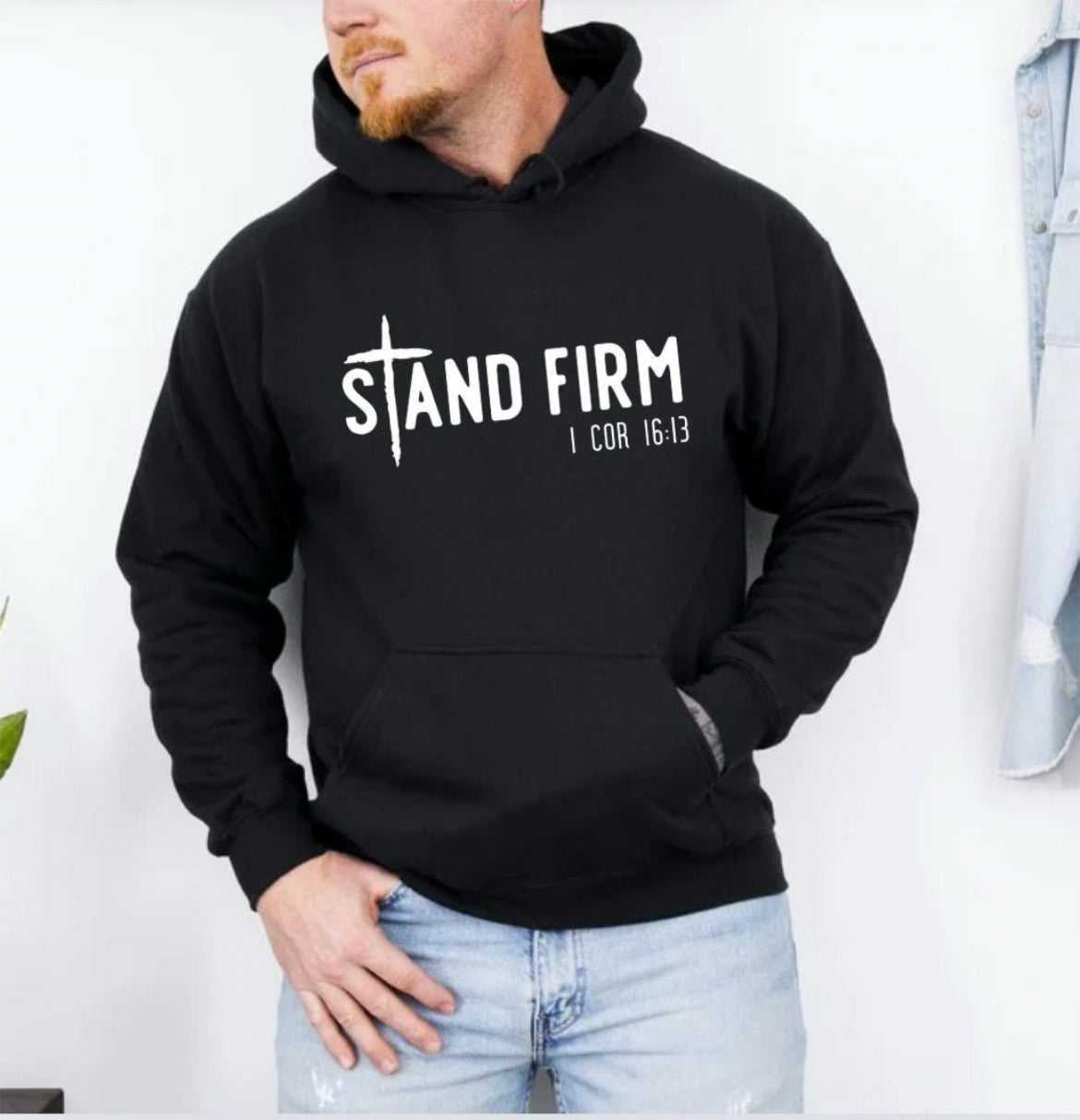 Black hoodie that says, "Stand firm" where the "t" is a cross. Underneath in smaller letters it says, "1 Corinthians 16 verse 13."