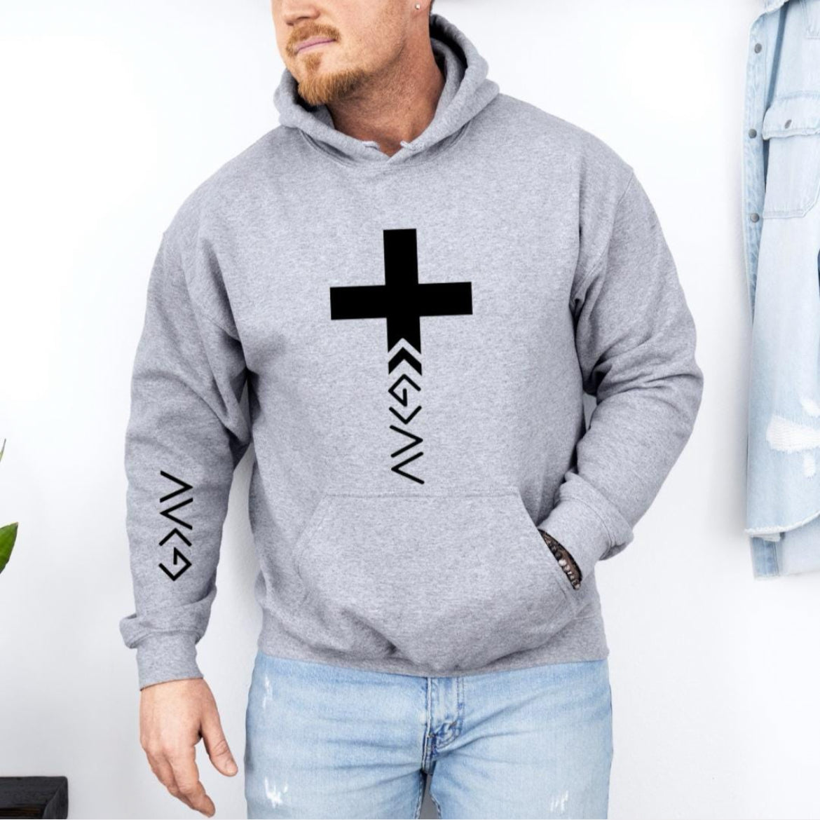 Light gray hoodie that has a cross with the "God is greater than the highs and lows" symbol on the bottom. The same symbol is on the sleeve.