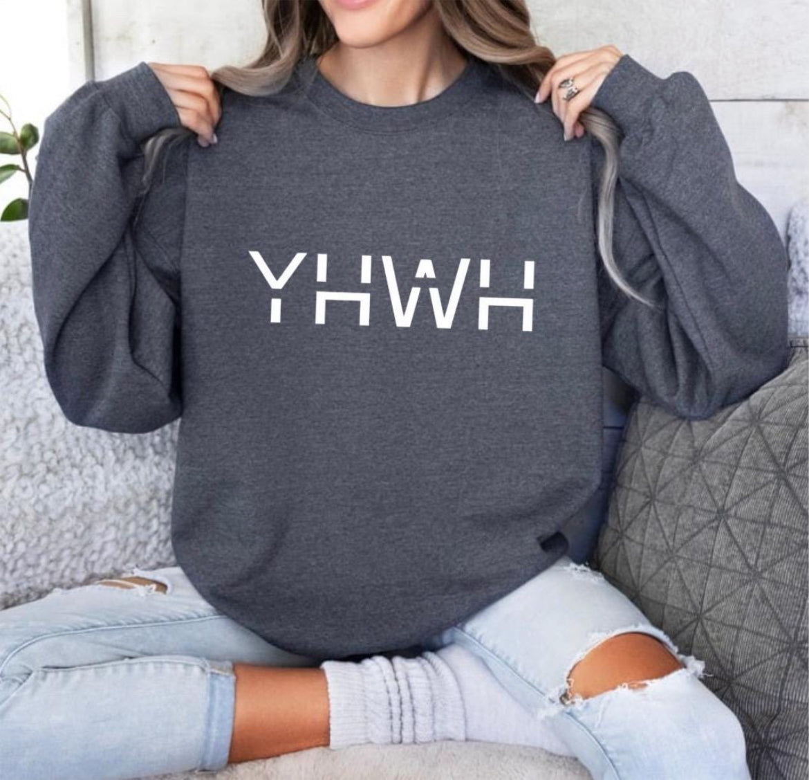 Dark gray crewneck sweatshirt that says, "YHWH" with a cross on the sleeve.