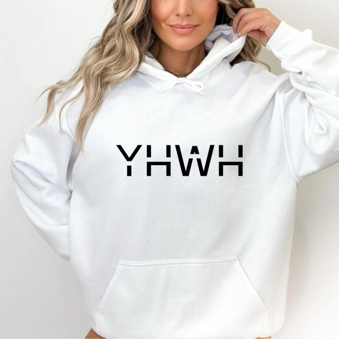 White hoodie that says, "YHWH" with a cross on the sleeve.