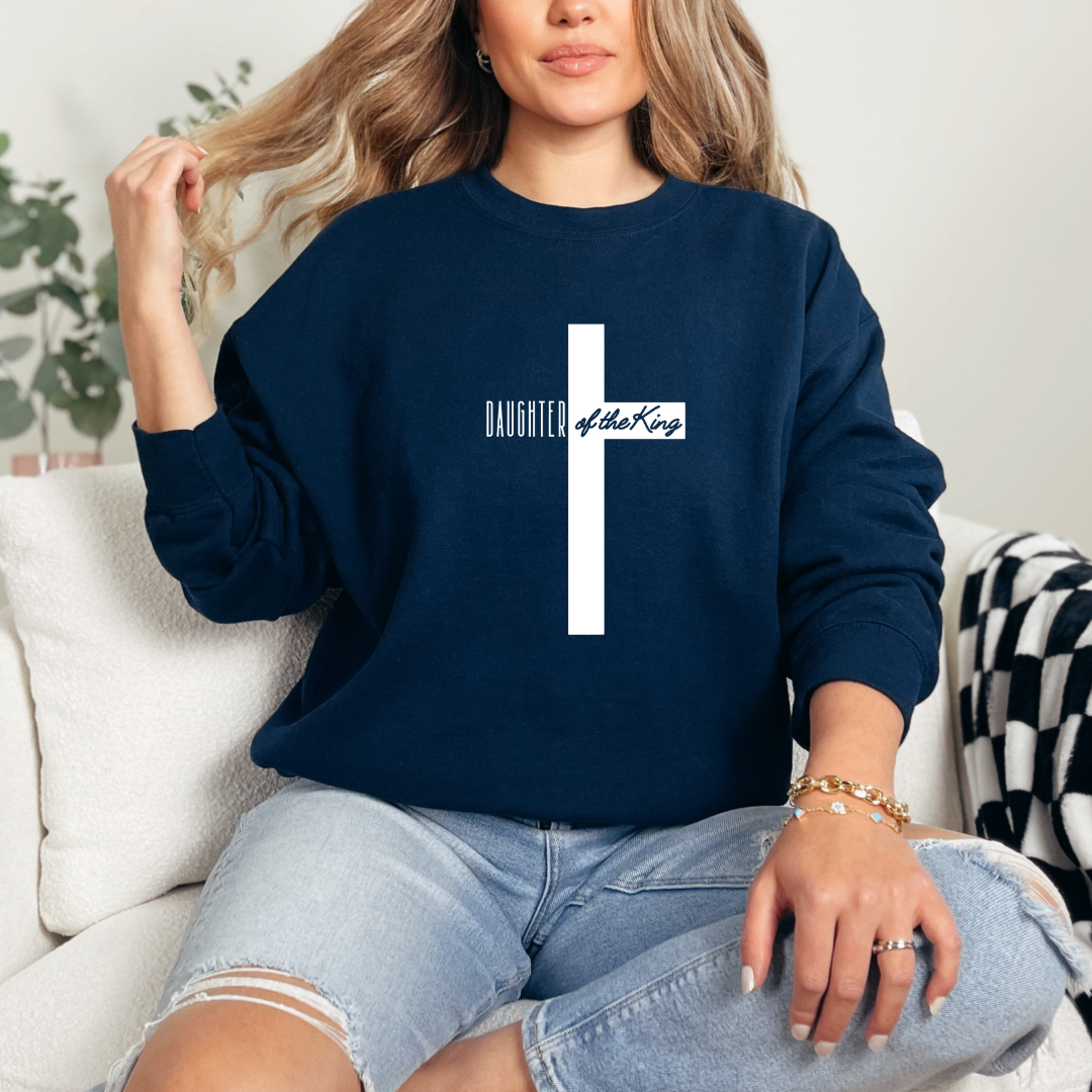 Navy sweatshirt that says, "daughter of the King" across the middle of a large cross.