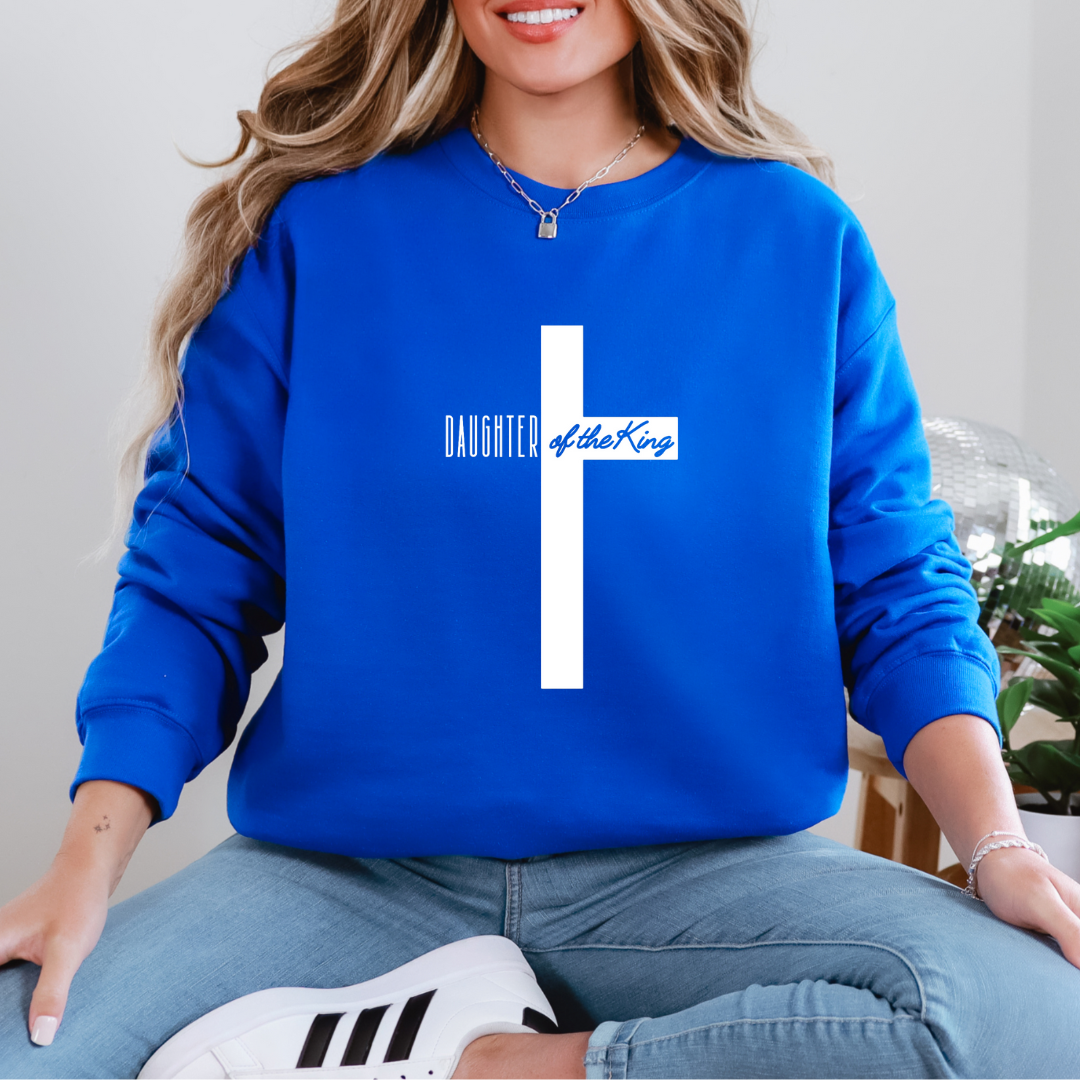 Blue sweatshirt that says, "daughter of the King" across the middle of a large cross.