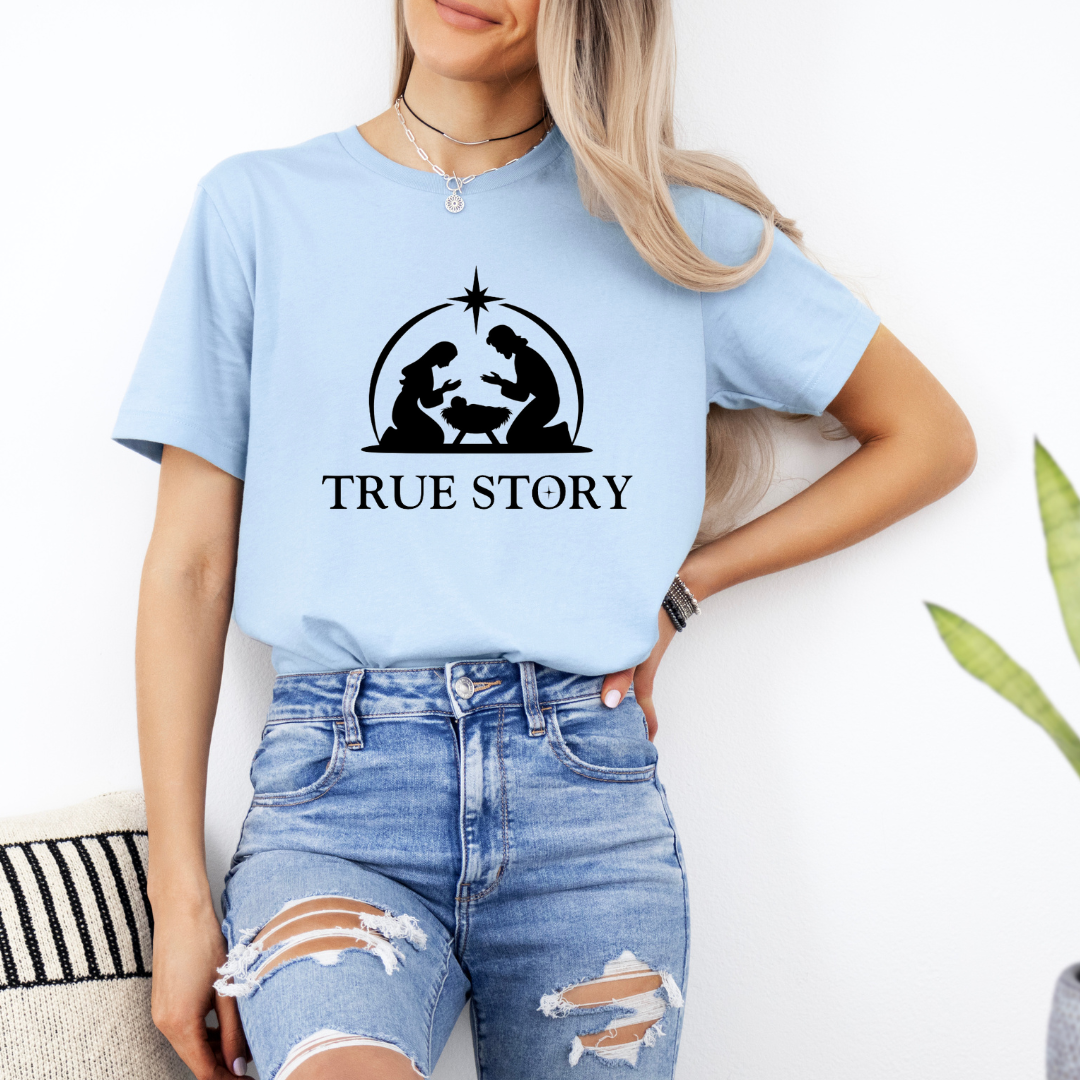 Baby blue crewneck t-shirt that says, “true story” with Mary, Joseph and baby Jesus in a manger. Christian Christmas Holiday attire.