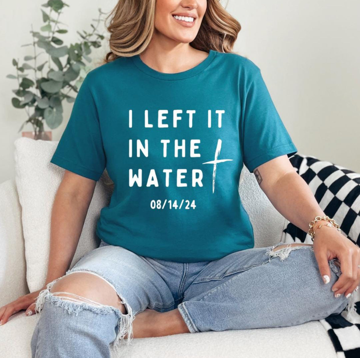 Deep teal crewneck t-shirt that says, “I left it in the water” with a custom baptism date underneath. 