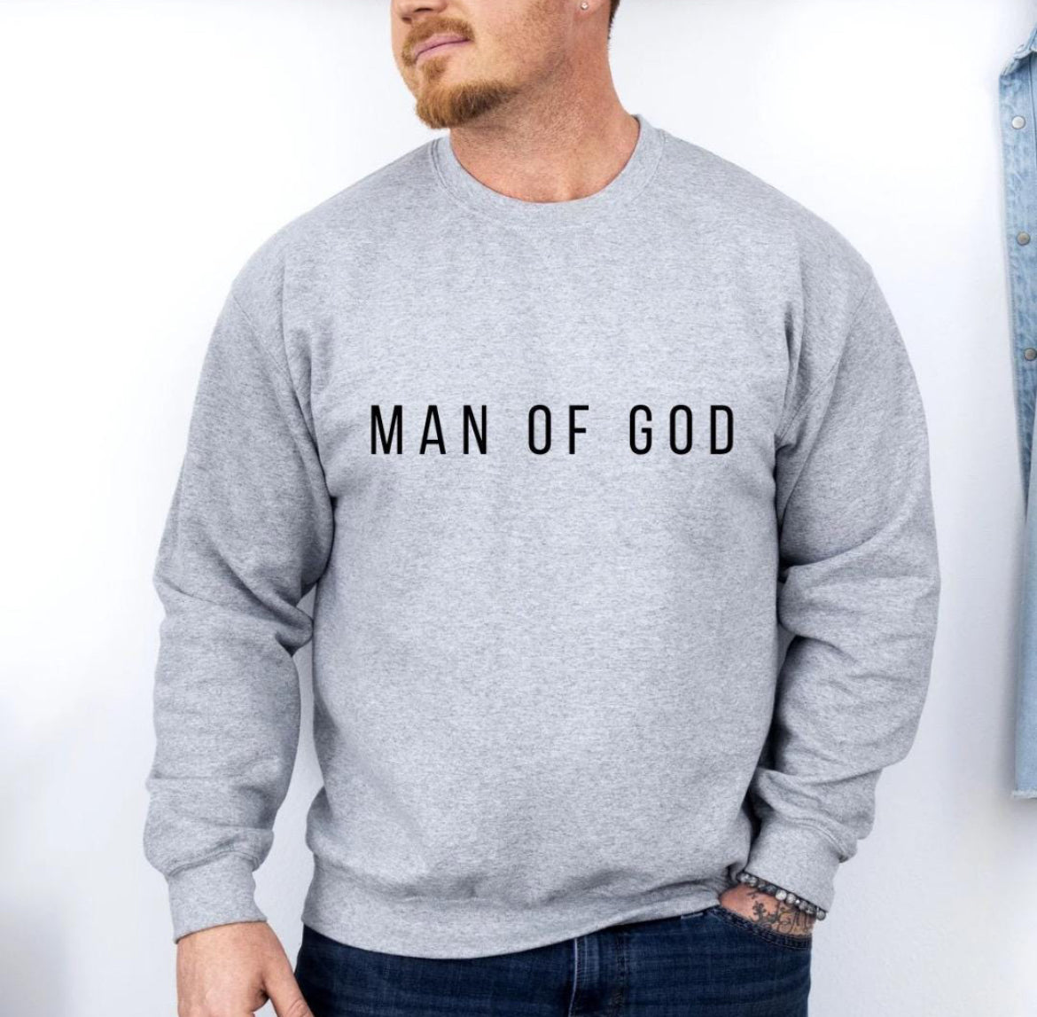 Light grey crewneck sweatshirt that says, "Man of God" in bold letters across the chest.