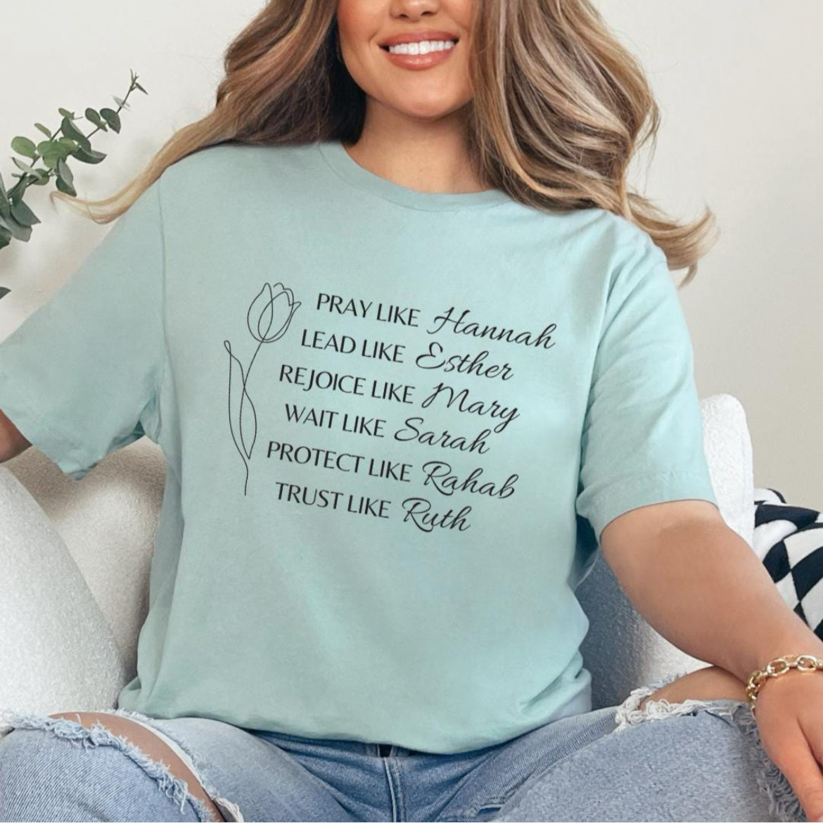 Dusty green crewneck t-shirt that says, “Pray like Hannah, lead like Esther, rejoice like Mary, wait like Sarah, protect like Rahab, trust like Ruth.”