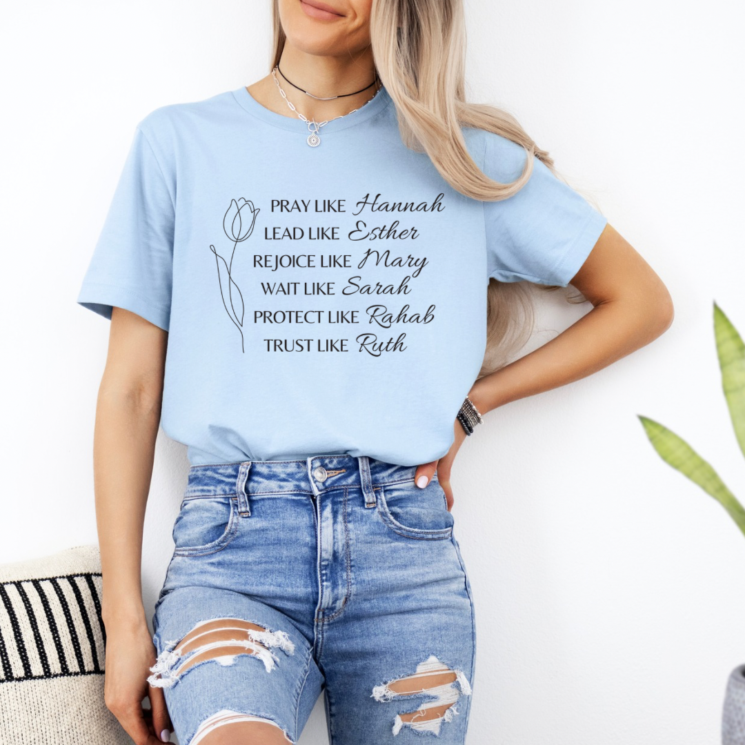 Baby blue crewneck t-shirt that says, "Pray like Hannah, lead like Esther, rejoice like Mary, wait like Sarah, protect like Rahab, trust like Ruth."