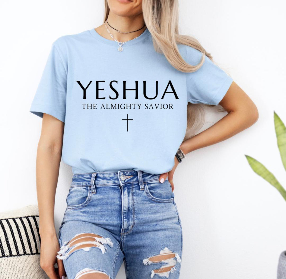 Baby blue Crewneck T-shirt that says, “Yeshua” in large letters. Underneath in smaller letters it says, “the almighty savior” and under that is a small cross. 