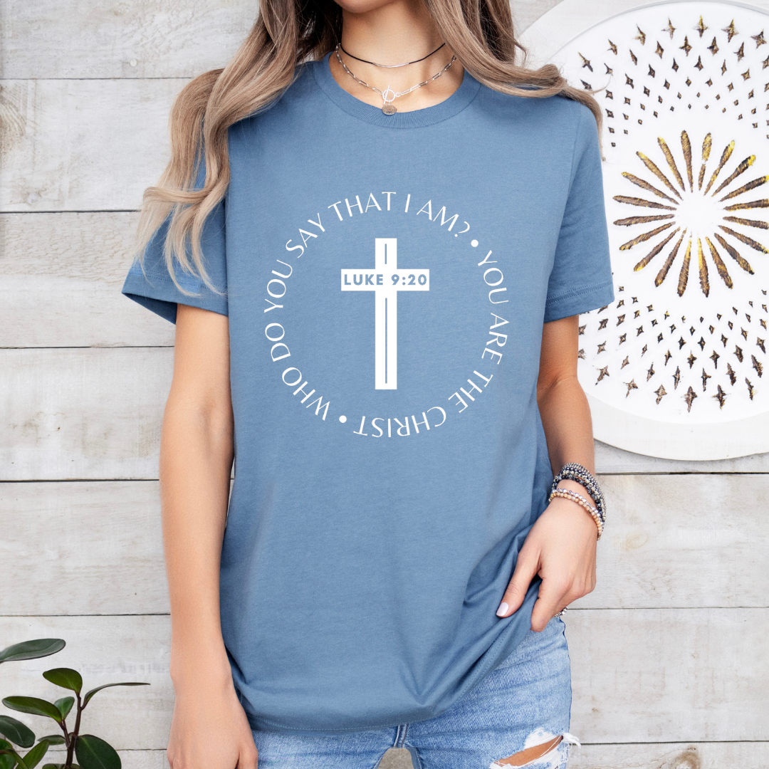 Steel blue crewneck t-shirt that says, “who do you say that I am? you are the Christ?” With a cross that says, “Luke 9:29” through the middle. 