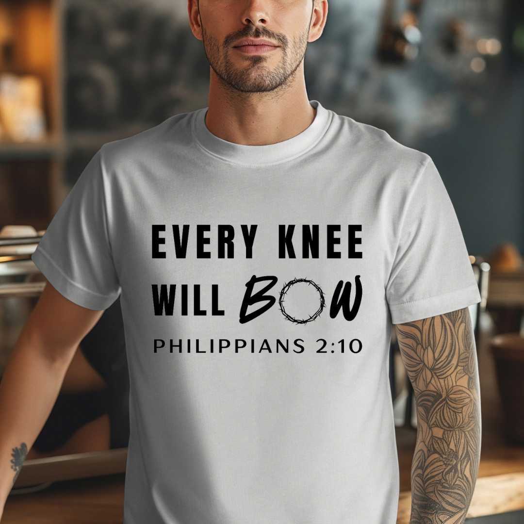 Grey crewneck t-shirt that says, “every knee will bow. Philippians 2:10” with a crown of thorns as the “o” in bow.