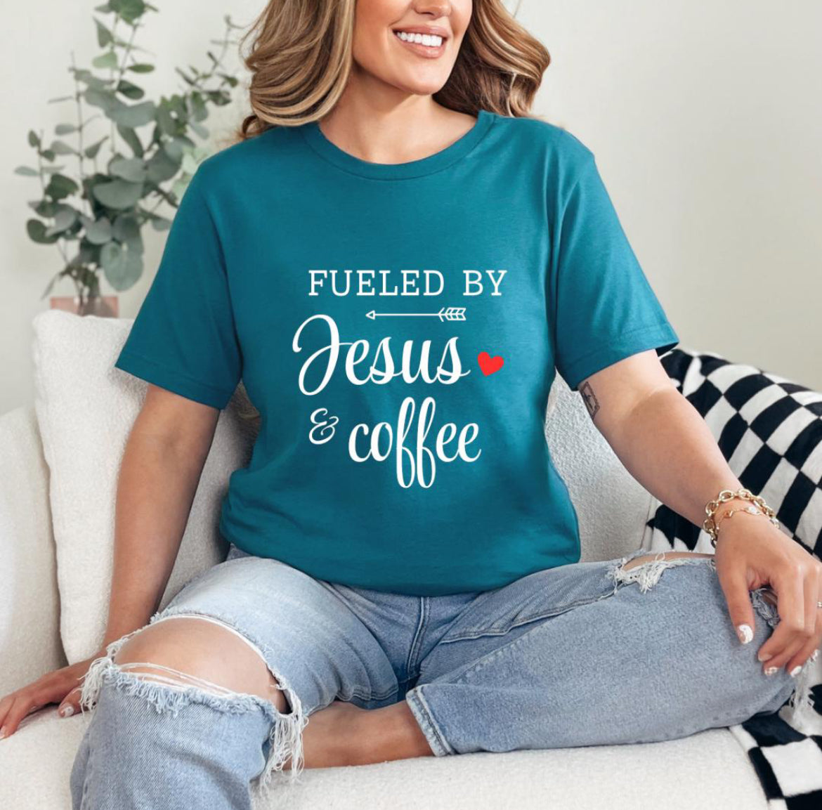 Deep teal crewneck t-shirt that says, “fueled by Jesus and coffee.”