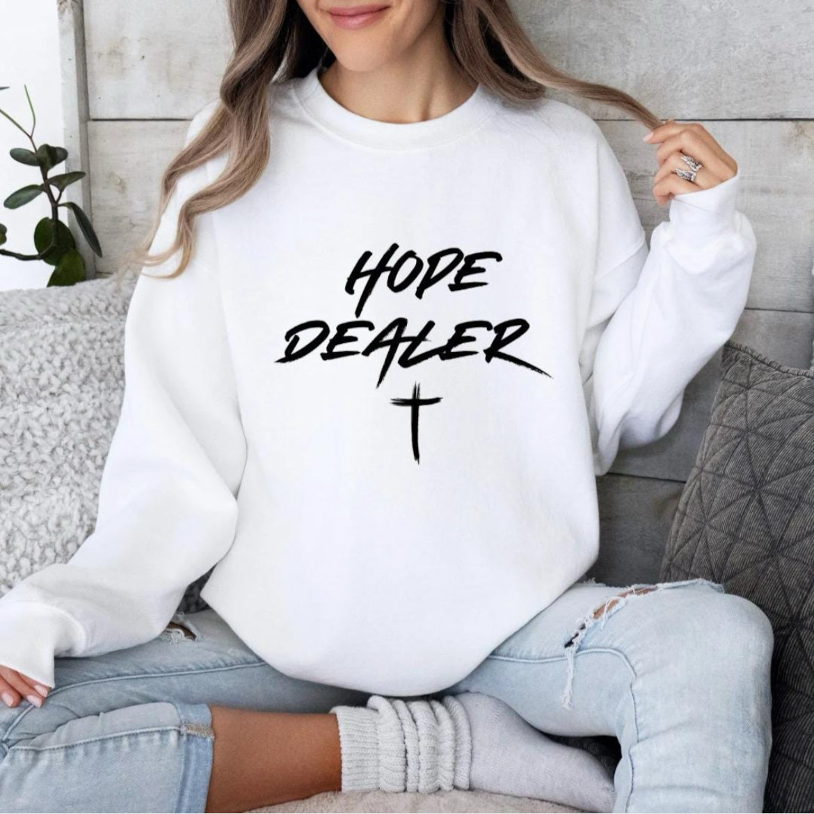 White Crewneck sweatshirt that says, “Hope dealer” in graffiti style writing with a cross. 