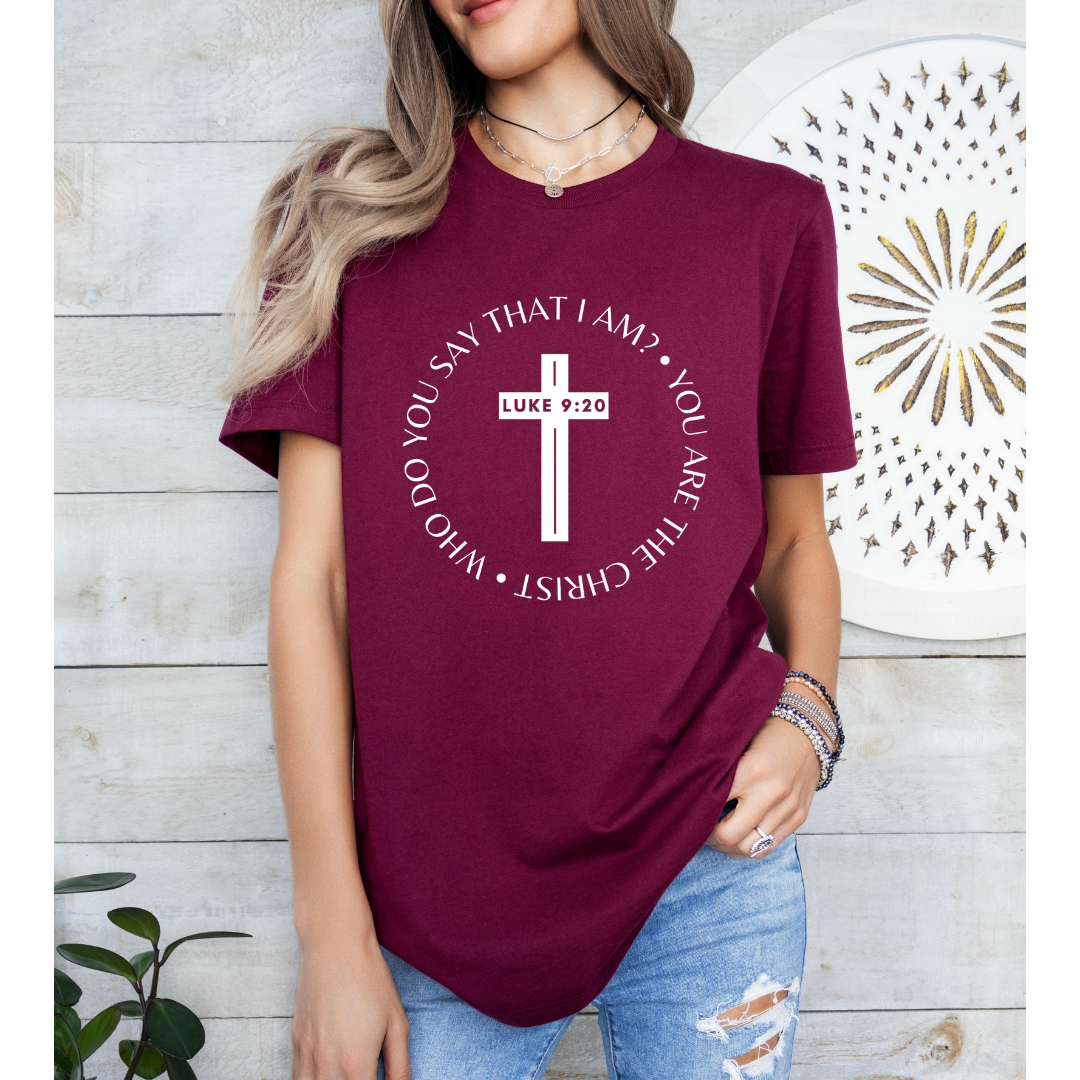 Maroon crewneck t-shirt that says, “who do you say that I am? you are the Christ?” With a cross that says, “Luke 9:29” through the middle. 