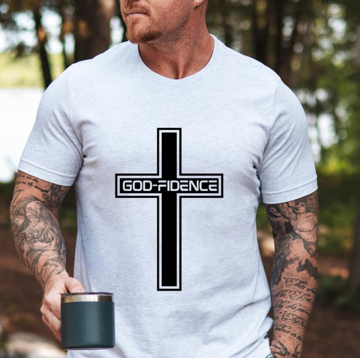 Ash white crewneck t-shirt that says, “Godfidence” inside of a cross. 