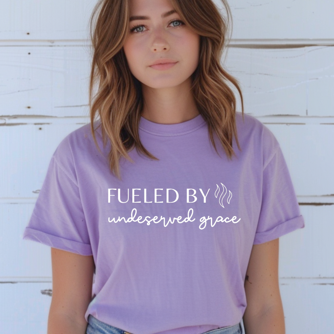 Lavender crewneck t-shirt that says, “Fueled by undeserved Grace”.