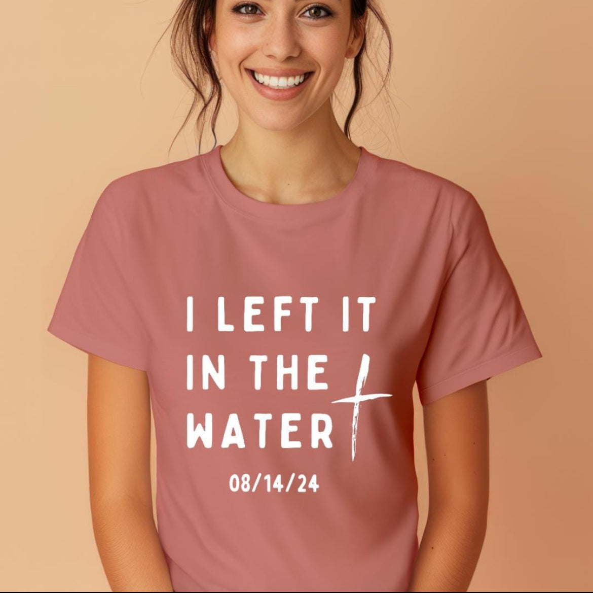 Mauve crewneck t-shirt that says, “I left it in the water” with a custom baptism date underneath. 