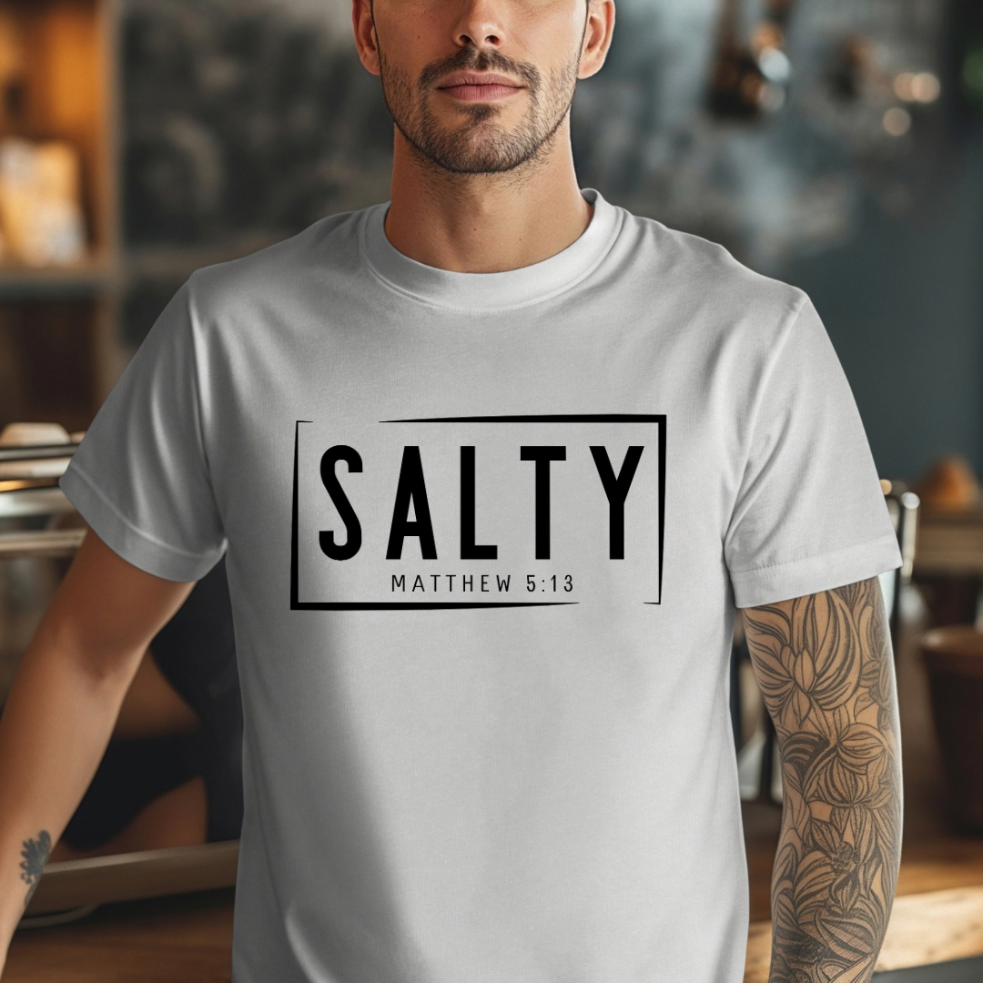 Grey crewneck t-shirt that says, “SALTY” in large capital letters. Underneath in smaller letters it says, “Matthew 5:13.” Christian Apparel