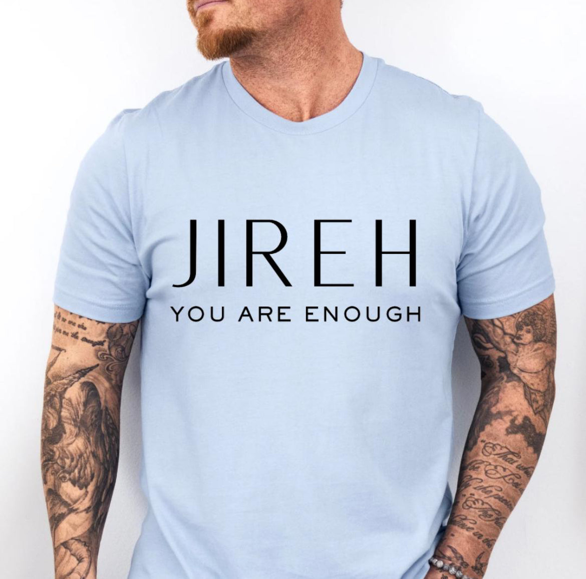 Baby blue crewneck t-shirt that says, “jireh” in large letters. Underneath it says, “you are enough.”