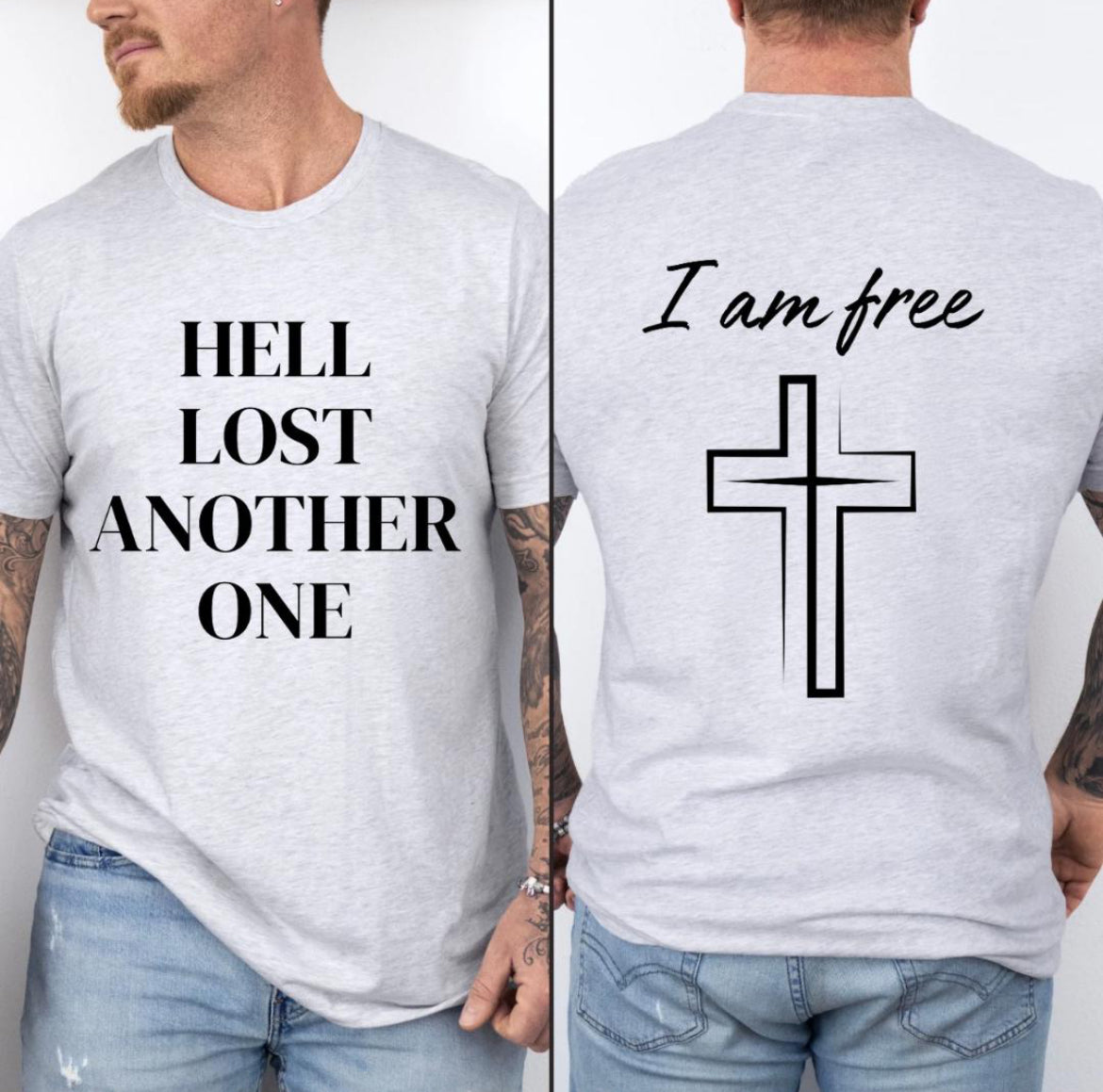 Ash white crewneck t-shirt that says, “Hell lost another one.” The back says, “I am free” with a cross image. 