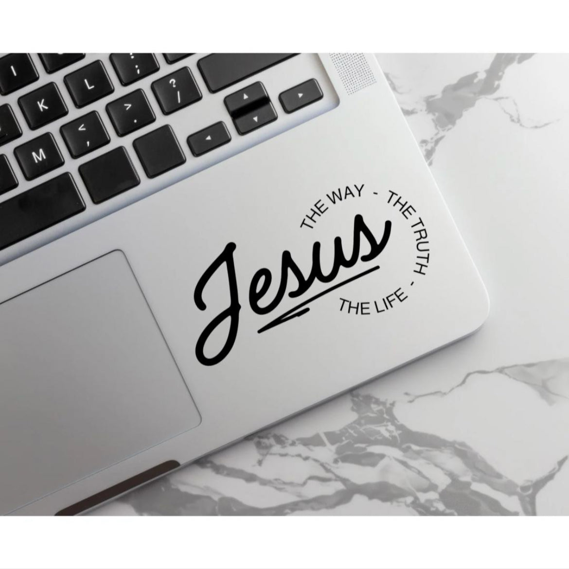 Laptop keyboard sticker decal that says, “Jesus - the way, the truth, the life.” The word “Jesus” is in large cursive letters. The other words are in print and round the ending of “Jesus”.