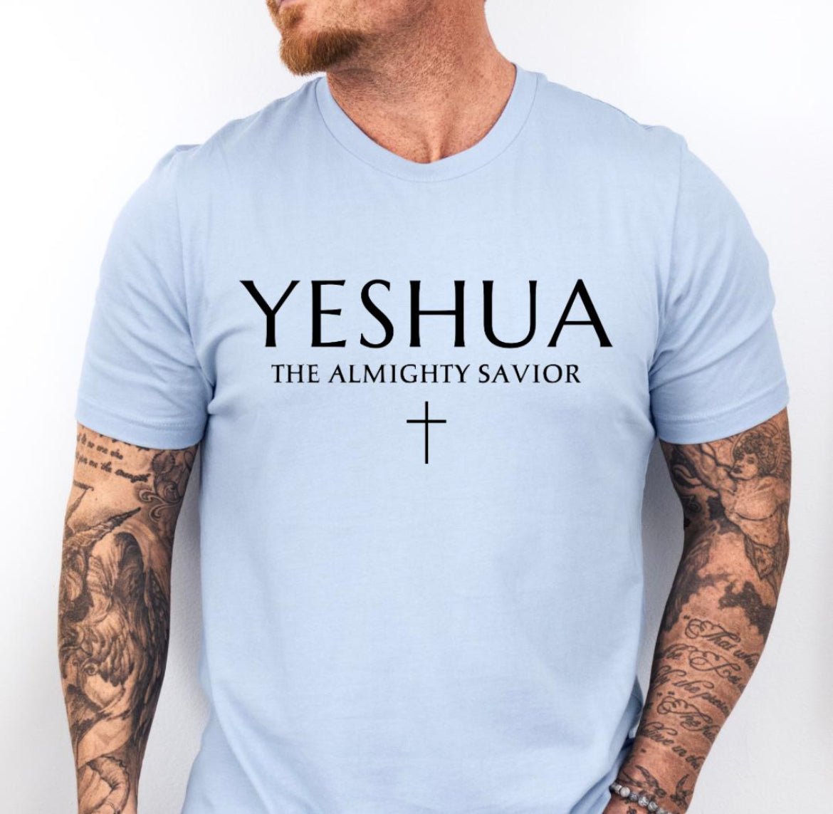 Baby blue Crewneck T-shirt that says, “Yeshua” in large letters. Underneath in smaller letters it says, “the almighty savior” and under that is a small cross. 