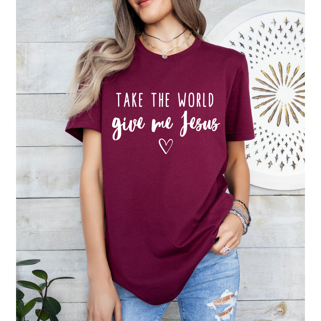 Maroon crewneck t-shirt that says, “take the world, give me Jesus” with a heart graphic.