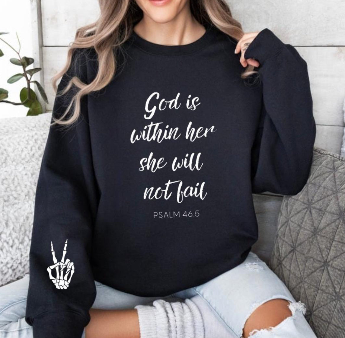 Black crewneck sweatshirt that says, "God is within her she will not fail." Underneath in smaller letters it says, "Psalm 46 5." On the sleeve there is a bones peace sing.