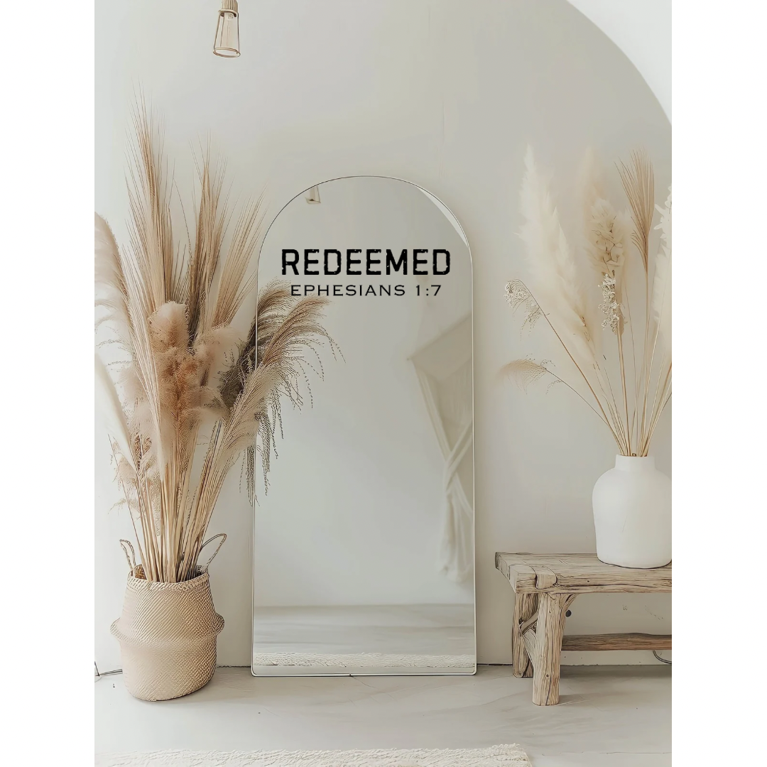 Mirror decal sticker that says, “Redeemed” in large bold distressed letters. Underneath in smaller capital letters it says, “Ephesians 1 7.”