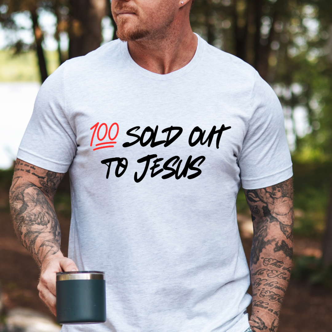 Ash white crewneck t-shirt that says, “sold out to Jesus” with a “100 emoji”.