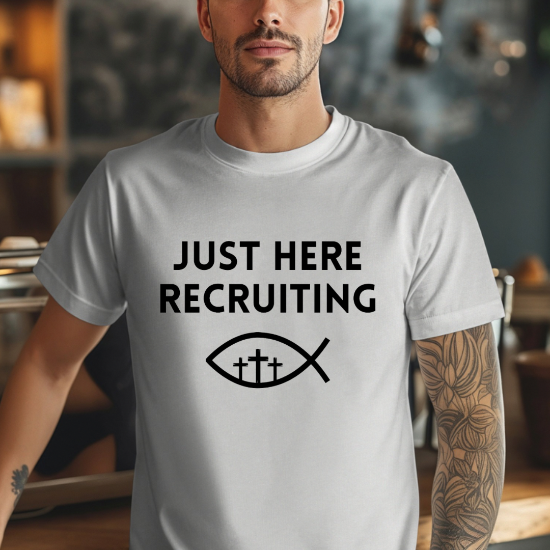 Grey crewneck t-shirt that says, “just here recruiting” with the ichthus fish symbol. In the middle of the fish are three crosses.