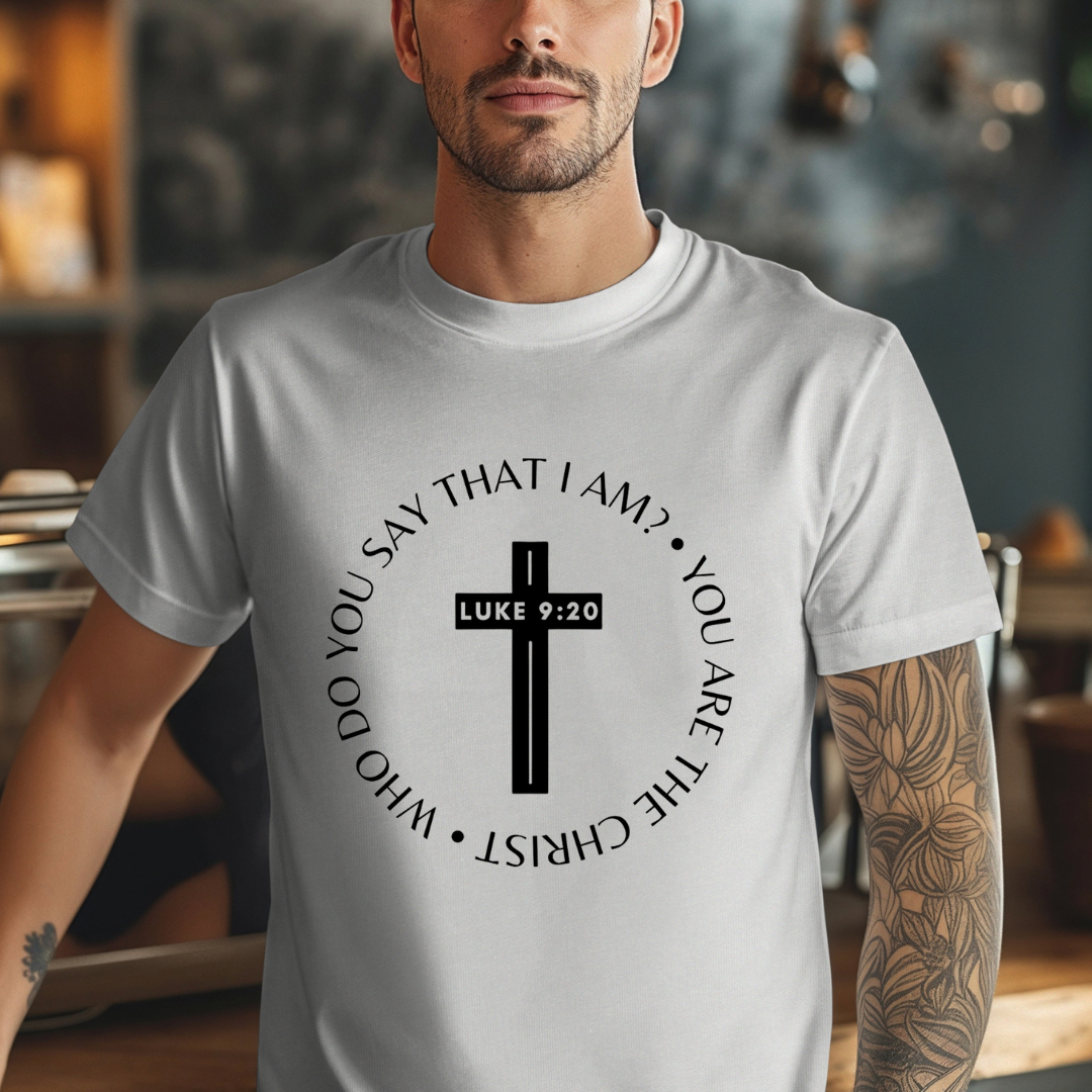 Gray crewneck t-shirt that says, “who do you say that I am? you are the Christ?” With a cross that says, “Luke 9:29” through the middle. 