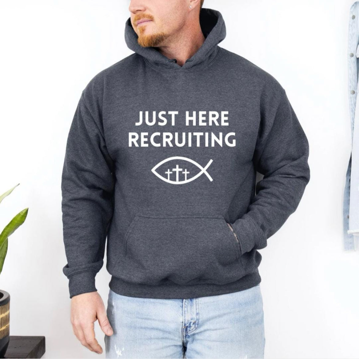 Dark gray hoodie that say, "Just here recruiting" with the ichthus fish symbol with three crosses inside the fish.