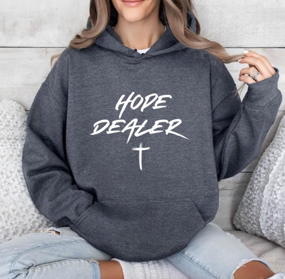 Dark gray heather hoodie that says, "Hope dealer" in graffiti style writing with an image of a cross.